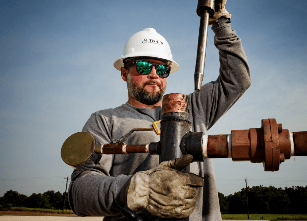 Technician performing lubricator plunger lift maintenance in the field